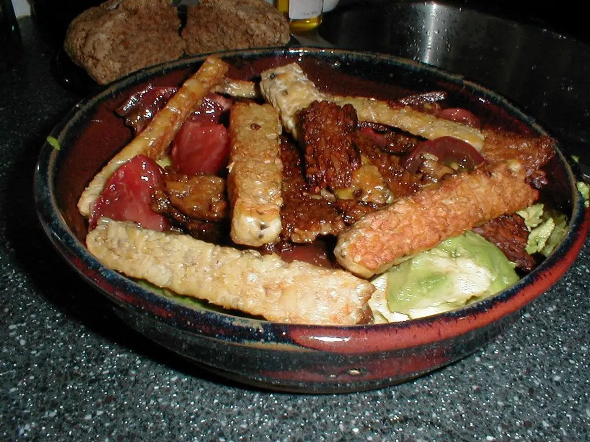 Cuenco con tiras de tempeh doradas, pimiento y verduras