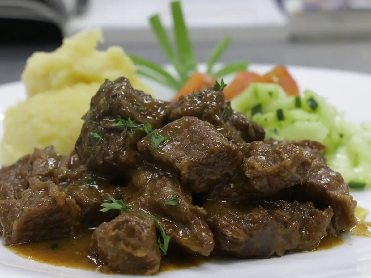 Trozos de ternera guisada en su salsa con puré de patata y ensalada de pepino