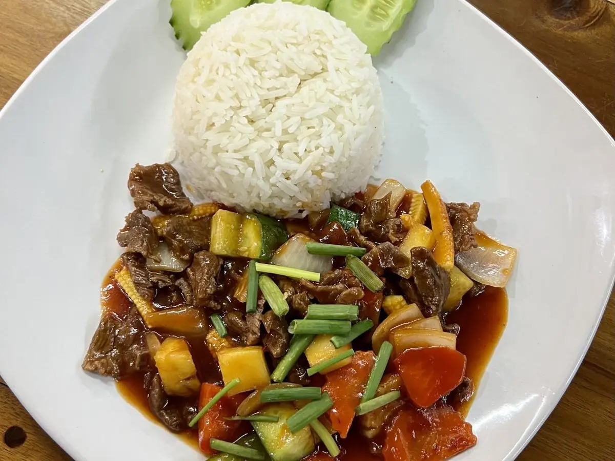 Ternera salteada con verduras y cebolleta junto a arroz blanco