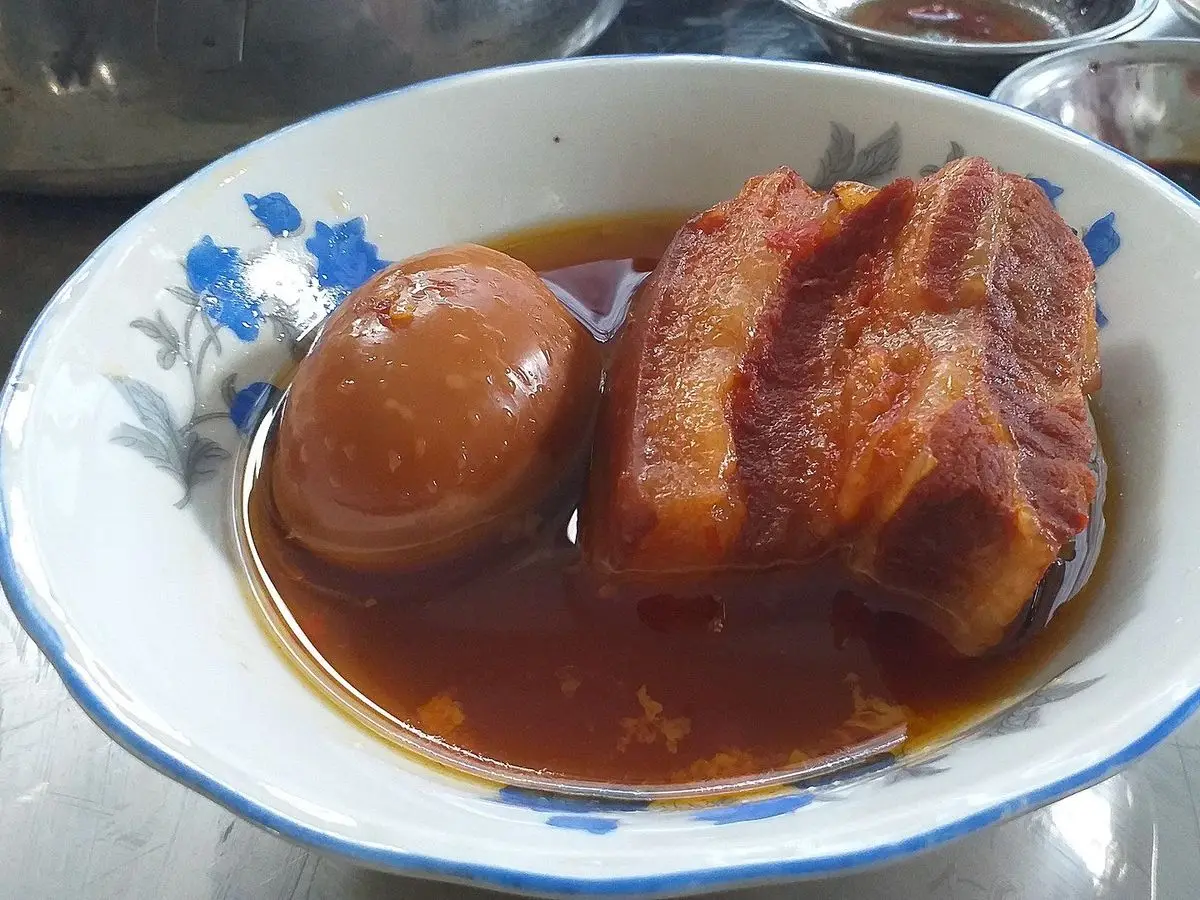 Cuenco con panceta de cerdo caramelizada y huevo cocido en salsa oscura brillante