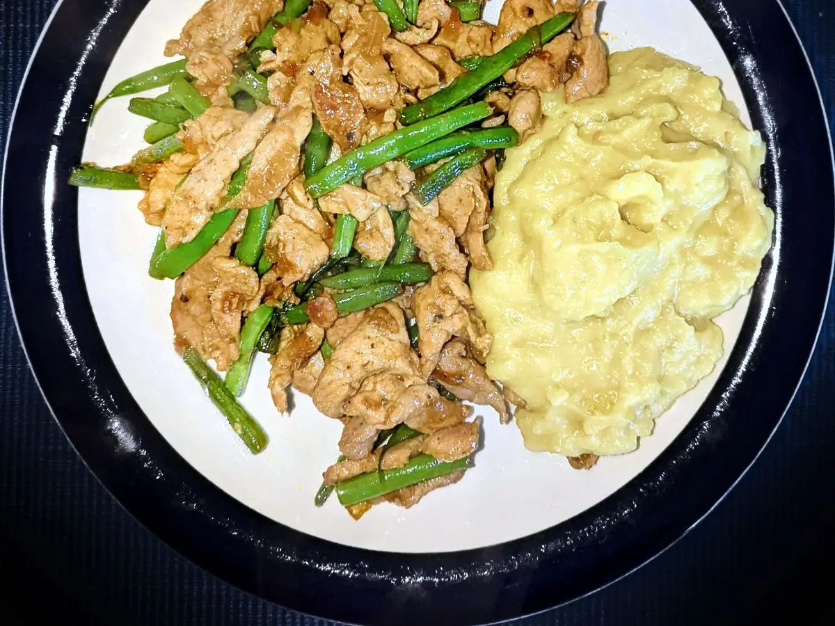 Plato con tiras salteadas, judías verdes y puré de patata cremoso