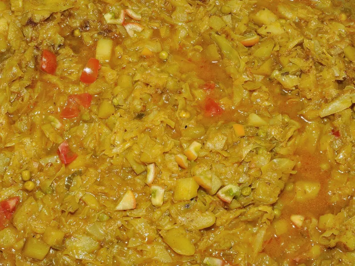 Plato de repollo guisado con patata y especias amarillas