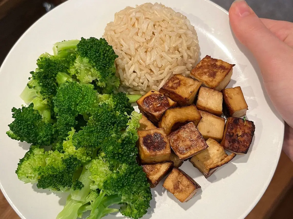 Plato con dados de tofu dorados al horno, ramilletes de brócoli al vapor y arroz integral