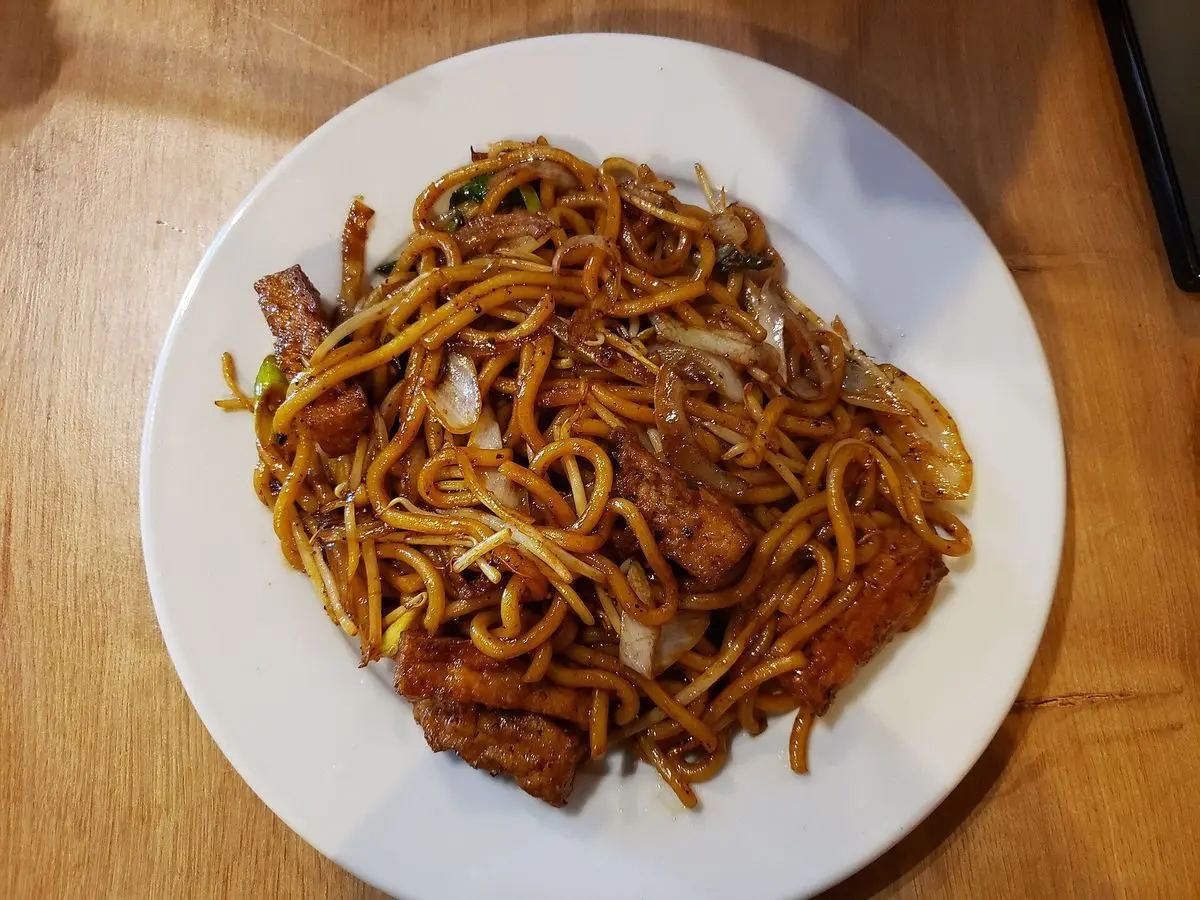 Plato blanco de fideos salteados con tofu y pimienta negra