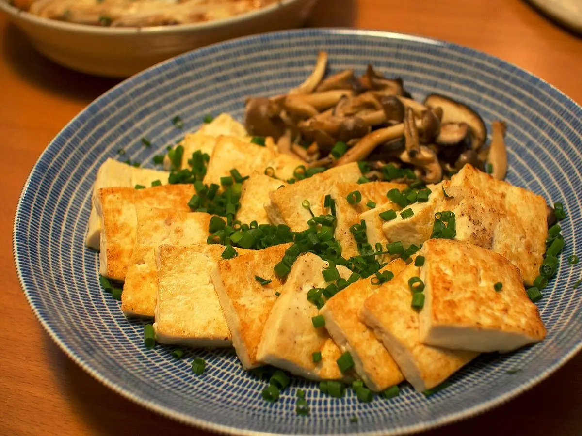 Plato con filetes de tofu a la plancha, setas salteadas y cebollino