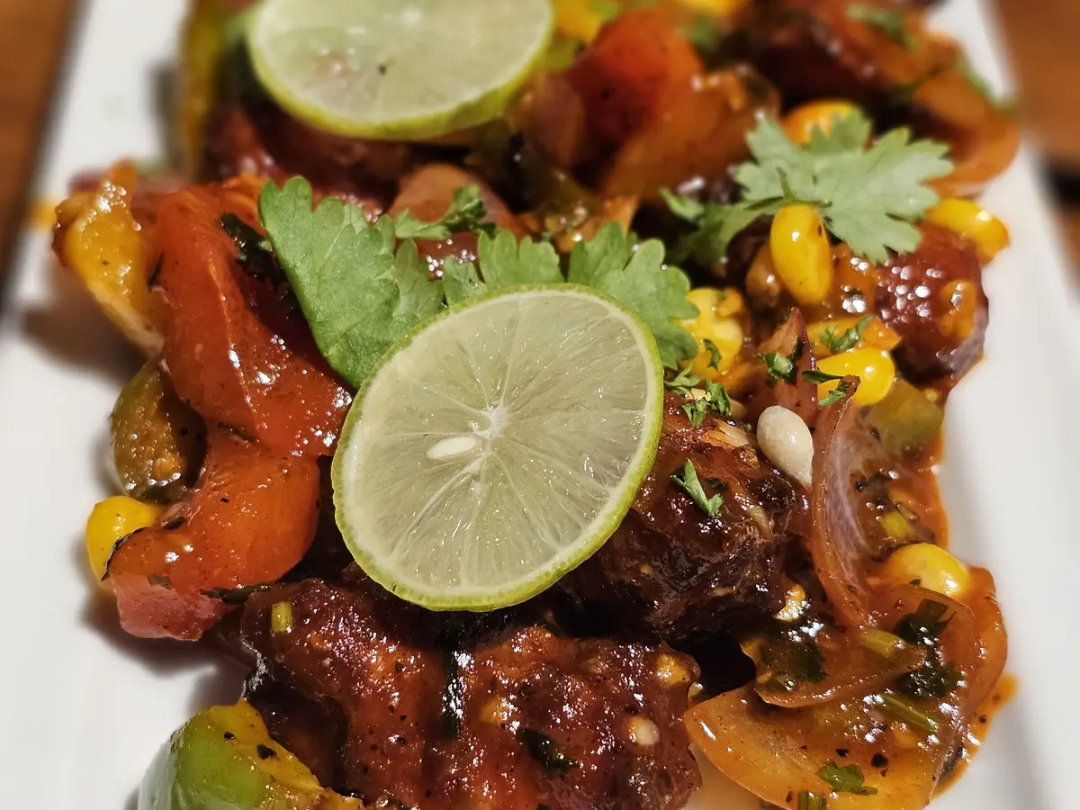 Salteado picante de verduras con cilantro y rodajas de lima