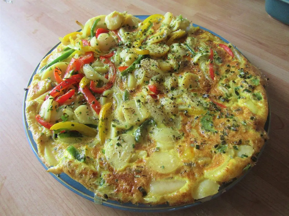 Tortilla española con pimientos rojos y verdes y patata en un plato