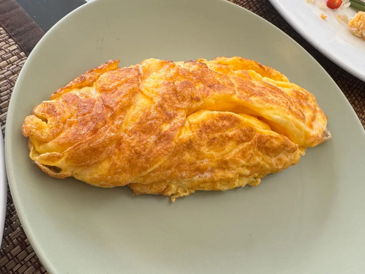 Tortilla doblada y dorada en un plato gris claro