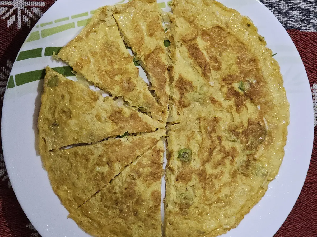 Tortilla española cortada en porciones sobre un plato blanco