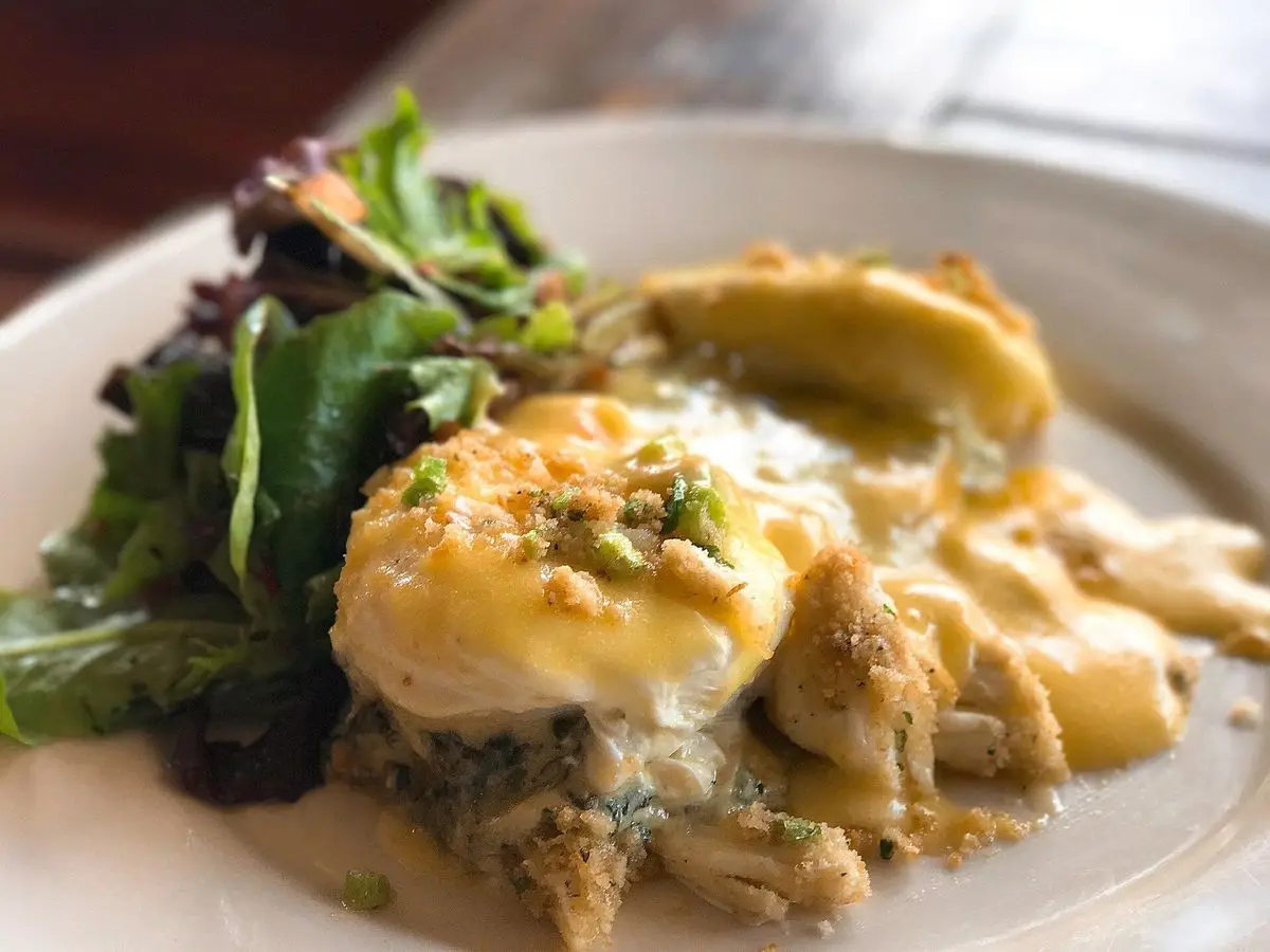 Huevos poché con hollandaise sobre alcachofas y espinacas salteadas con ensalada de hojas verdes
