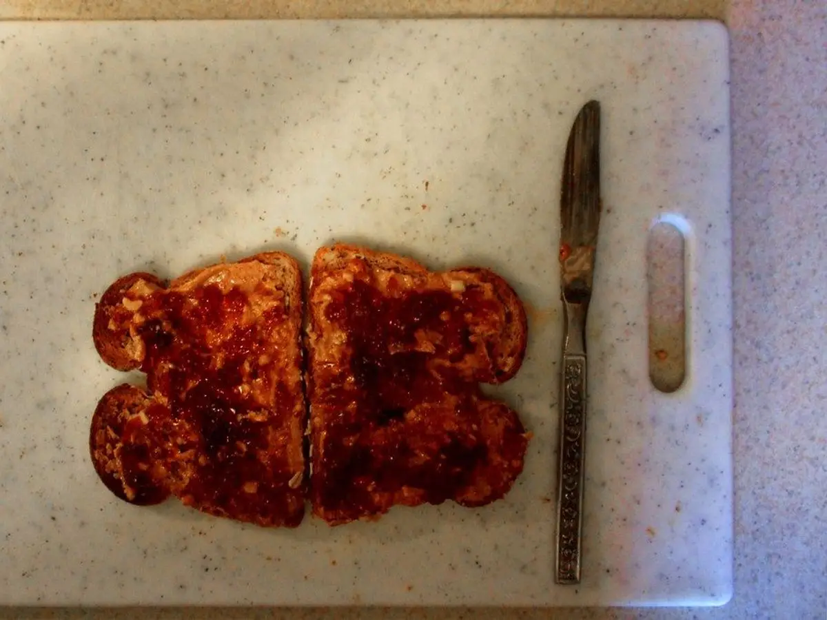 Dos tostadas con mermelada sobre una tabla de cortar con un cuchillo