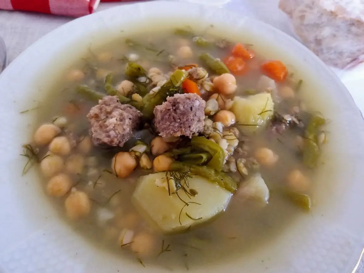 Plato hondo de olla de trigo con garbanzos, patata, zanahoria, verdura y albóndigas