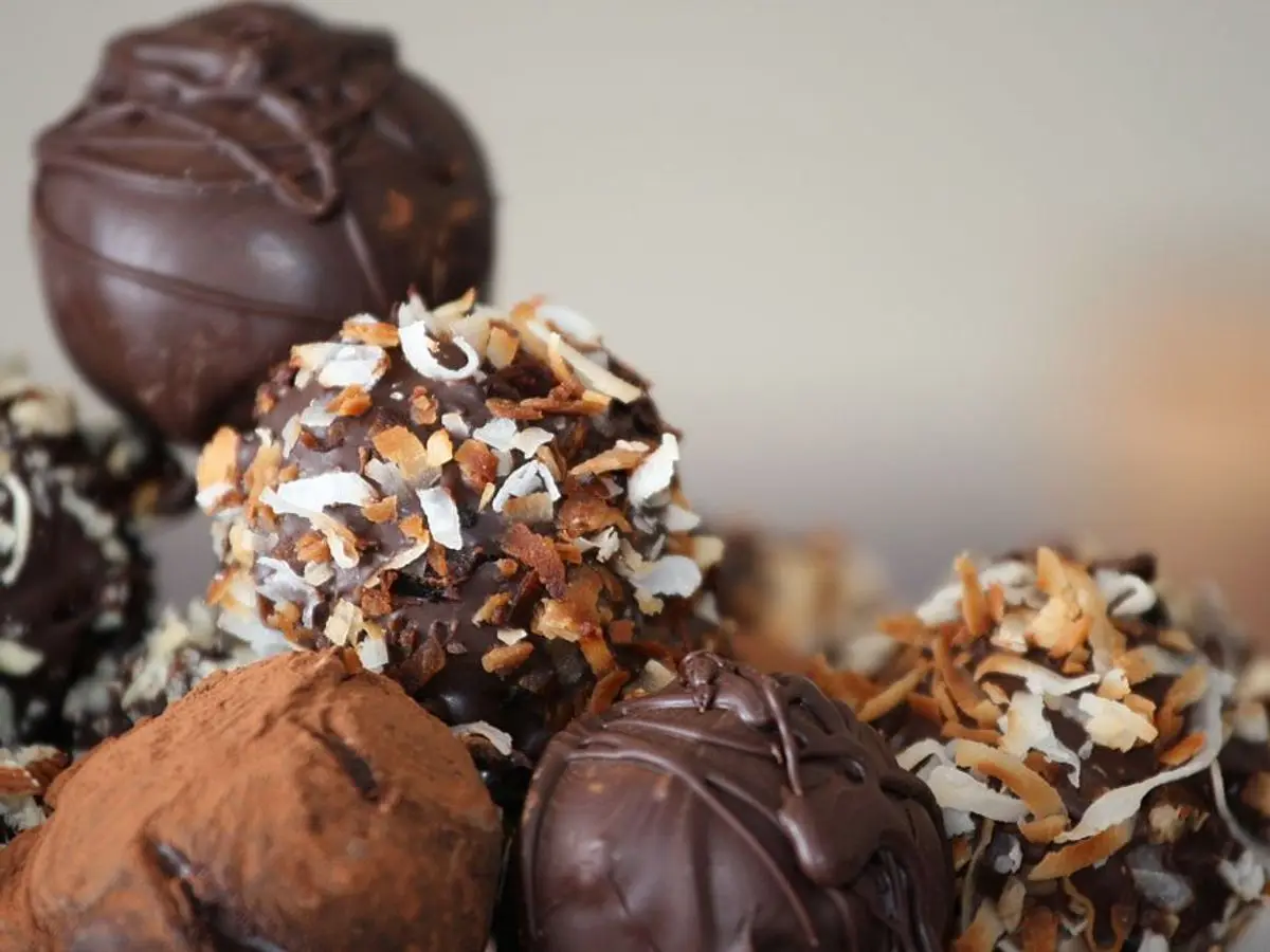 Trufas de chocolate redondas rebozadas con cacao y coco, en primer plano