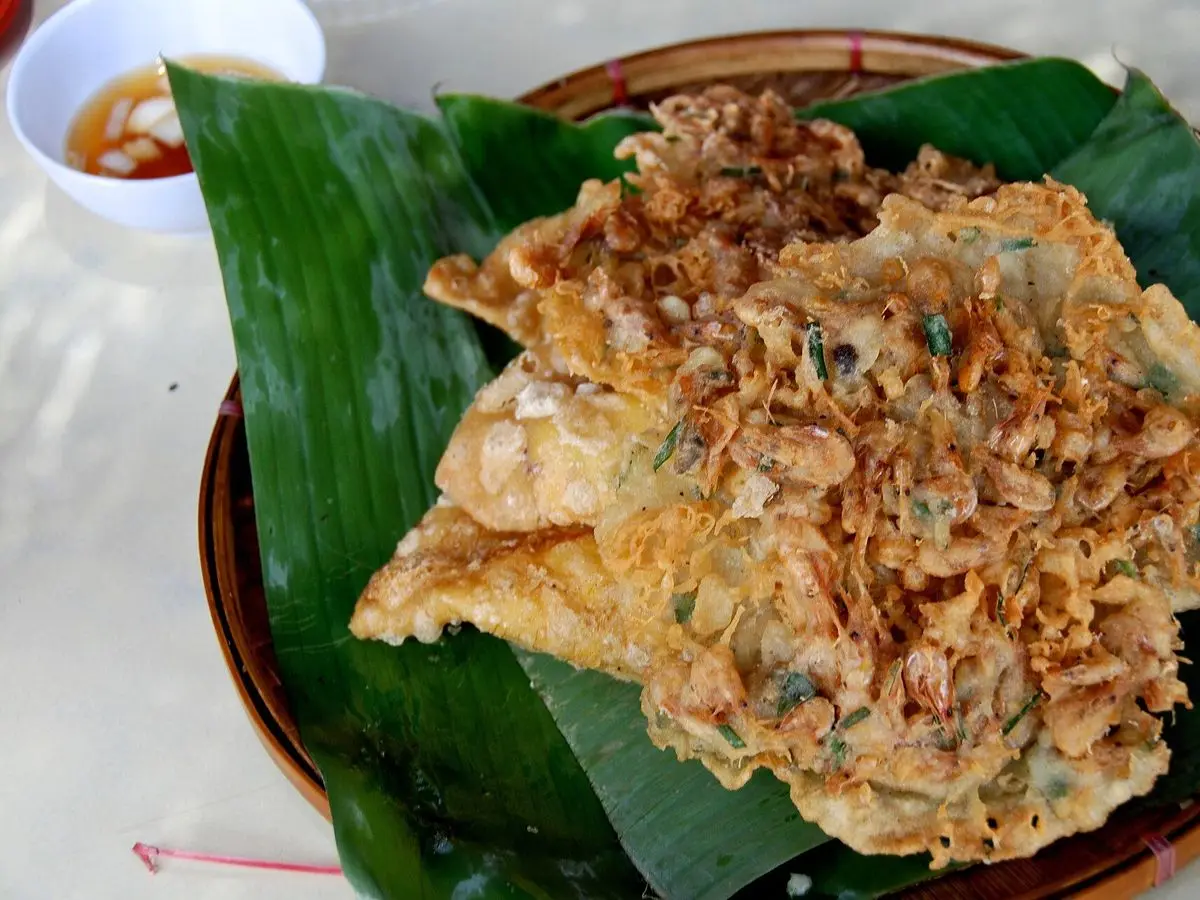 Tortita frita crujiente de verduras ralladas, ukoy filipino, servida sobre una hoja de plátano