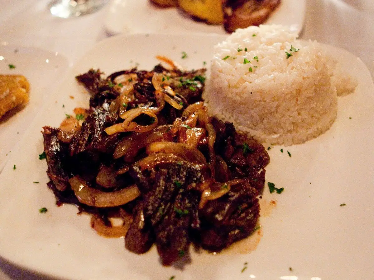 Plato de vaca frita con ternera deshebrada y cebolla salteada junto a arroz blanco