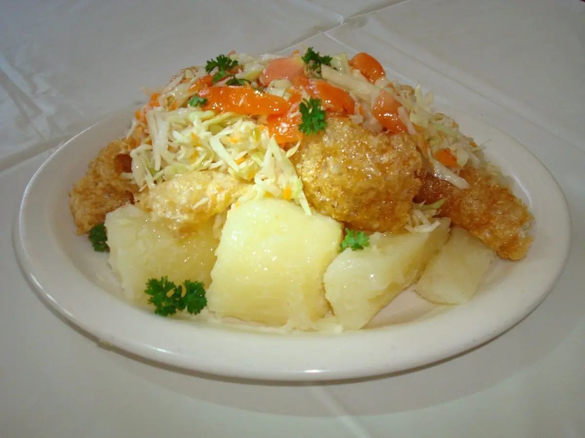 Plato de vigorón con yuca cocida, chicharrón y ensalada de repollo con tomate