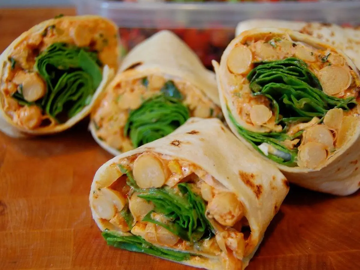 Wraps cortados por la mitad rellenos de garbanzos especiados, espinacas y calabaza