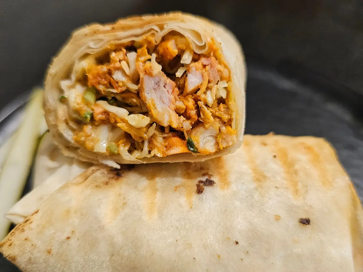 Wrap cortado por la mitad relleno de pollo, arroz y verduras