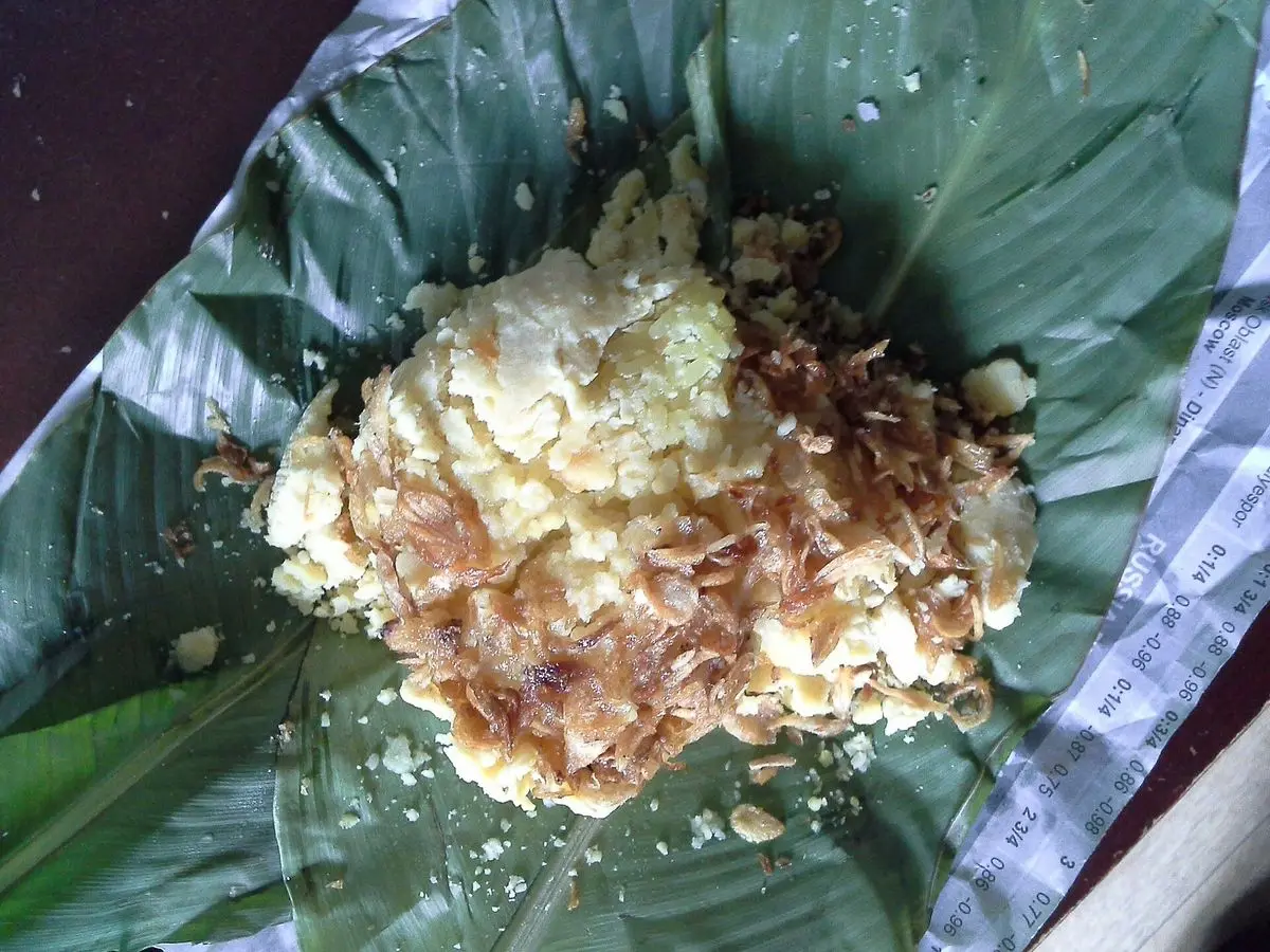 Arroz glutinoso con judía mungo desmenuzada y cebolla frita crujiente sobre una hoja de plátano