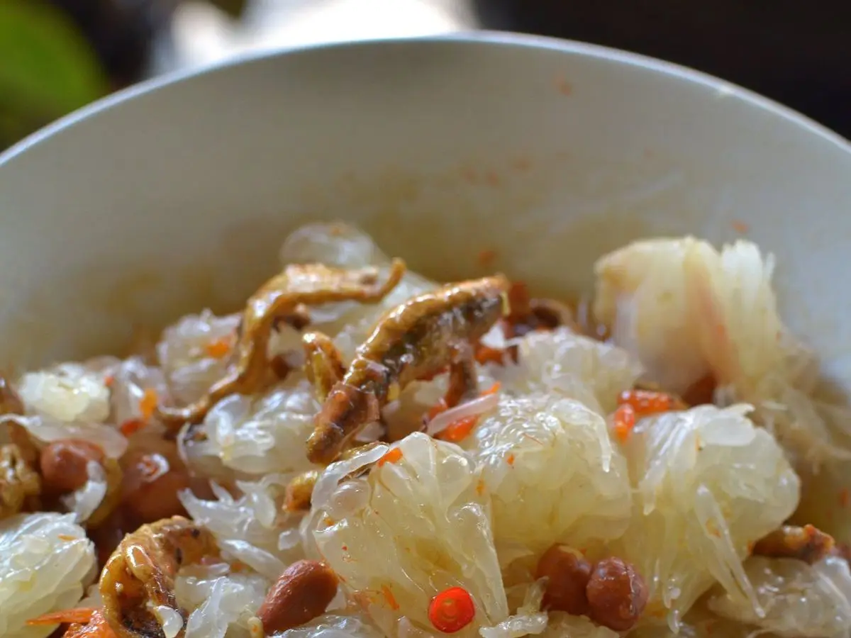 Ensalada tailandesa de gajos de pomelo con camarones secos, cacahuetes y chile