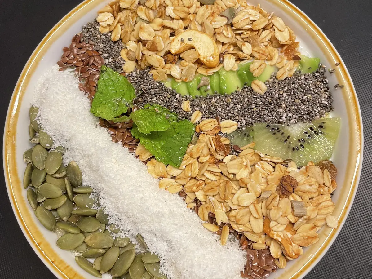 Bol de yogur con granola, coco, kiwi, chía y pipas de calabaza