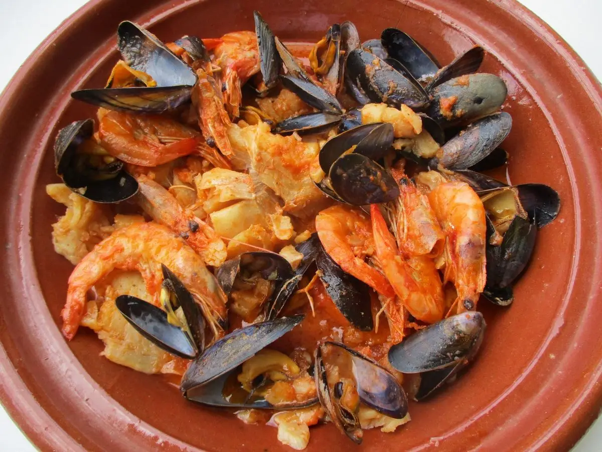 Cazuela de barro con gambas, mejillones y pescado en salsa de tomate