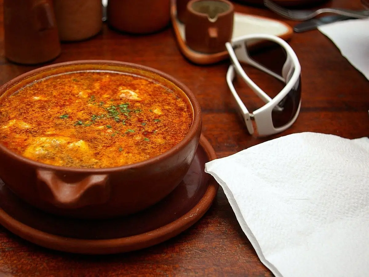 Cazuela de barro con sopa de ajo anaranjada con pimentón y pan desmigado